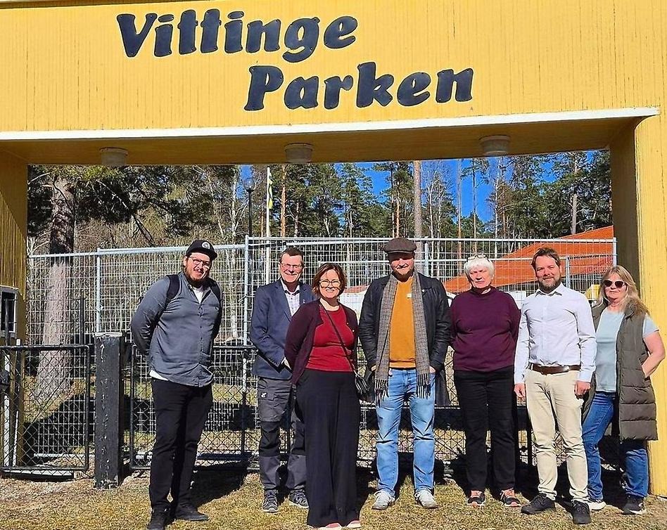 En grupp människor samlade under en stor entréskylt där det står Vittingeparken