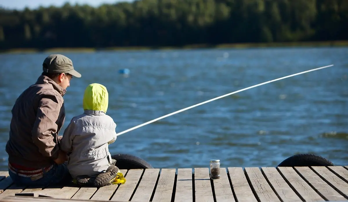 Man och barn på brygga fiskar