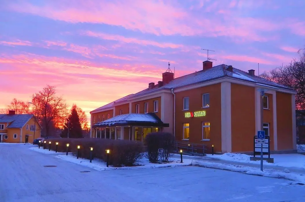 Heby kommunhus i vinterskymning med rosa och lila himmel