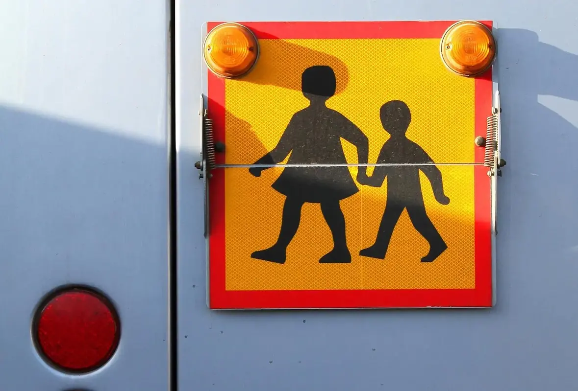 Skolbusskylt bak på en buss