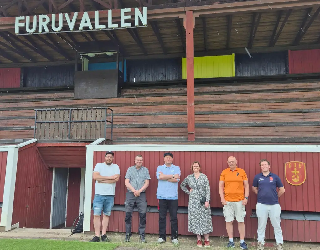 Kommunledningen tillsammans med styrelsen av Tärnsjö IF framför skylt Furuvallen