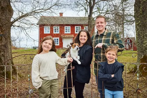 Familj i Vittinge ute på sin tomt och leker med sin hund